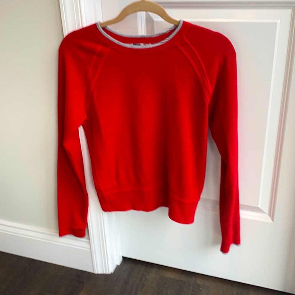 Athletica red cotton sweater with grey around the collar.  Thumb holes .